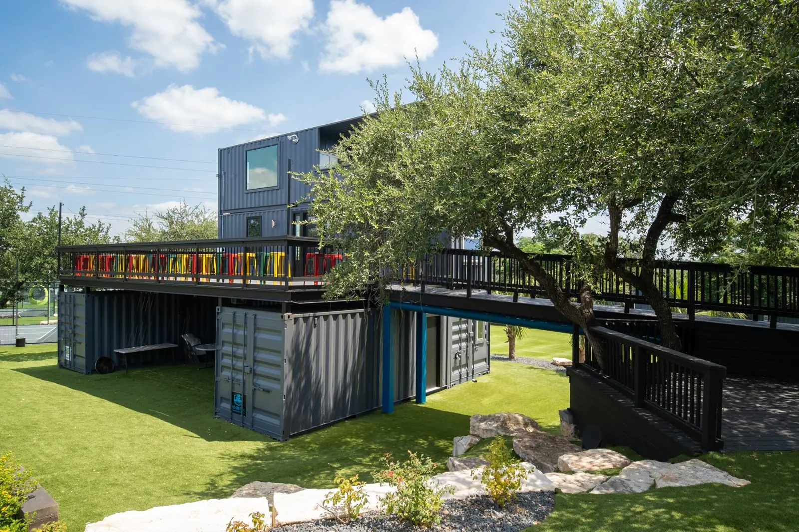 Trosky's two-story container clubhouse and deck under the oaks