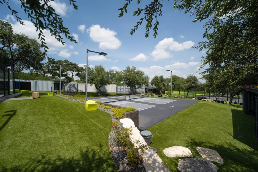 Limestone stepping-stone path through the turf toward the courts