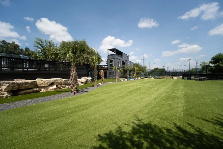 Full multi-sport turf field lined with palms and oaks